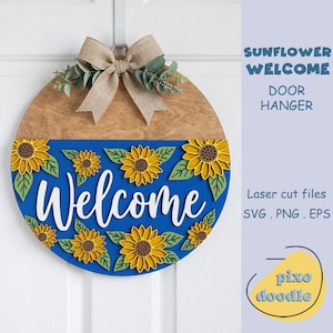 Könnte beinhalten: Ein runder Türhänger aus Holz mit einem blauen unteren Teil mit gelben Sonnenblumen und dem Wort "Welcome" in Weiß. Der obere Teil ist aus Naturholz, verziert mit einer Schleife aus Jute und Grünzeug. Der Text "Sunflower Welcome Door Hanger" ist sichtbar.