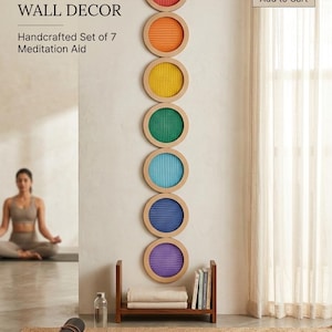 May include: A set of seven artisanal chakra mesh wall decorations. Each circular piece is a different colour: red, orange, yellow, green, blue, indigo, and violet. The text reads "ARTISANAL CHAKRA MESH WALL DECOR". The set is approximately 152 cm in height.