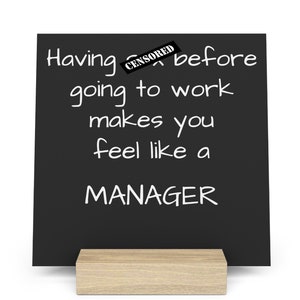 May include: A black chalkboard sign with a wooden stand. The sign reads "Having [CENSORED] before going to work makes you feel like a MANAGER."