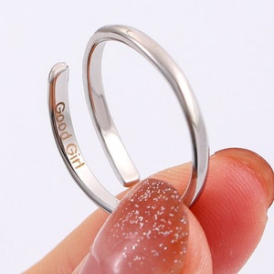 Może przedstawiać: Srebrny regulowany pierścionek z grawerem "Good Girl" na obrączce.