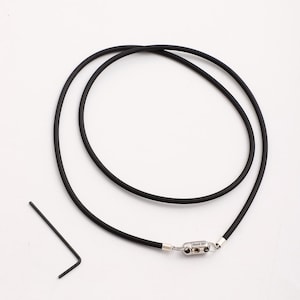 May include: A black rubber necklace with a silver clasp that says "Good Girl".