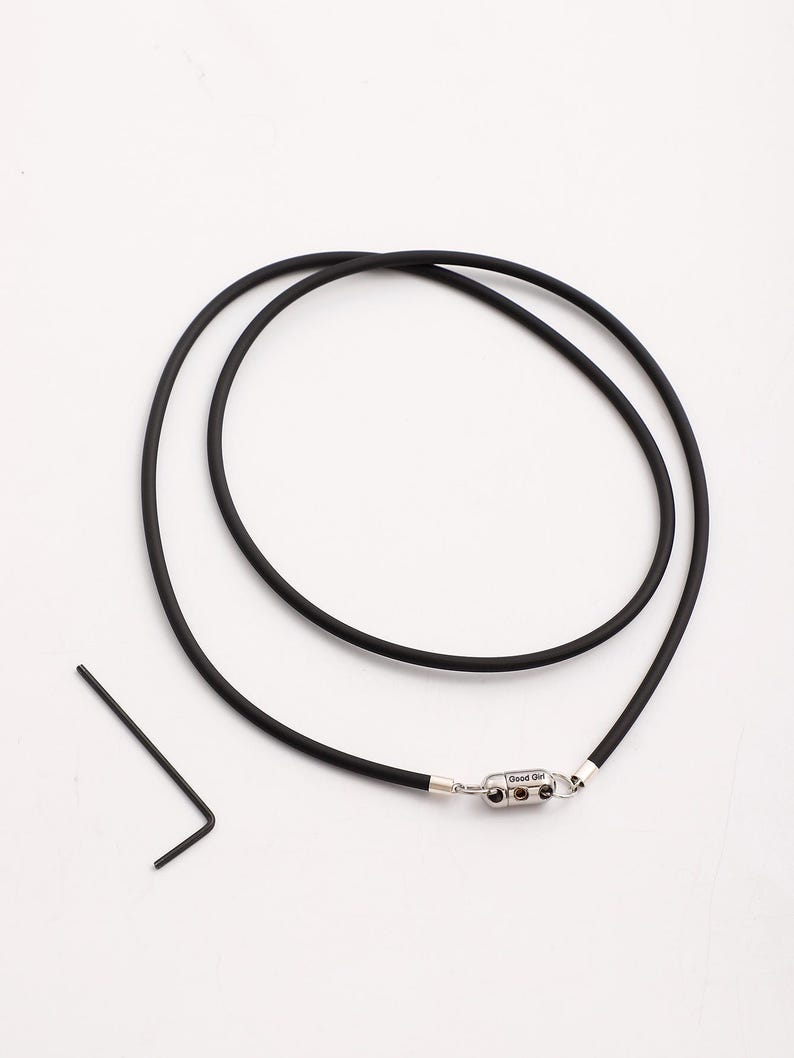May include: A black rubber necklace with a silver clasp that says "Good Girl".