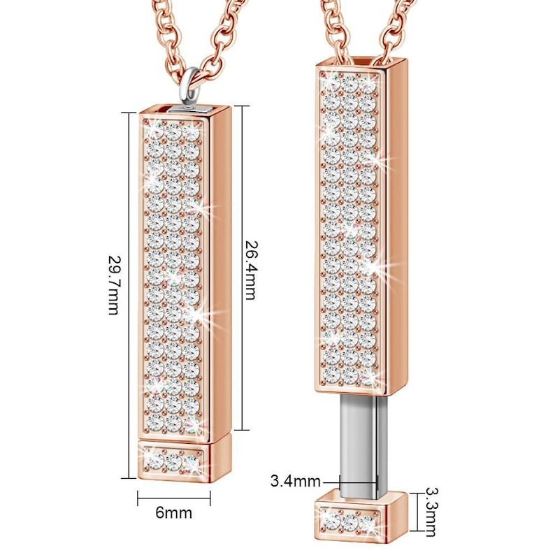 May include: A rose gold pendant necklace with a rectangular charm that is fully covered in clear cubic zirconia stones. The charm is 6.7 cm tall and 1.5 cm wide. The pendant is on a chain that is 75.4 cm long.