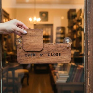 Peut inclure: Panneau en bois « OUVERT » et « FERMÉ » avec un curseur pour indiquer l'état du magasin. Le panneau est fixé à une porte vitrée avec de petites ampoules.