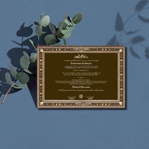 May include: A Conversion Certificate with ornate gold borders and text in English and Arabic. The certificate is brown with gold accents and includes the name "Michael Alexander". A sprig of eucalyptus is in the background.