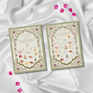 May include: Two wedding invitation cards with floral and decorative borders. The cards feature text and illustrations of symbolic items. The cards are on a white satin surface, with scattered pink rose petals.