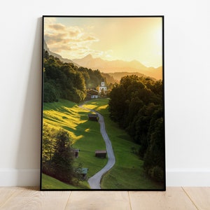 Può includere: Una fotografia panoramica di una strada tortuosa che conduce a un piccolo villaggio incastonato in una valle circondata da lussureggianti alberi verdi e montagne. Il sole sta tramontando, proiettando un caldo bagliore dorato sul paesaggio.