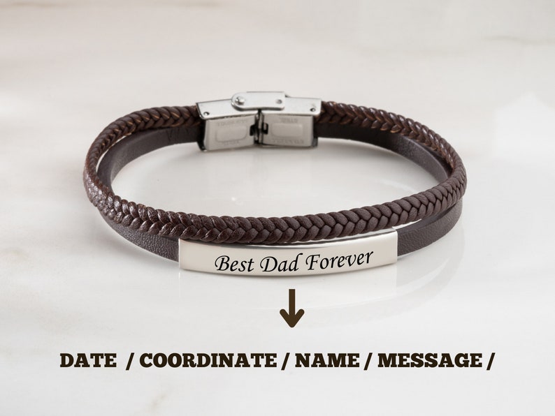 May include: Brown leather bracelet with a silver clasp and a silver plate engraved with the text "Best Dad Forever".