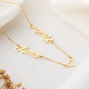 May include: Gold necklace with two names, "Lucia" and "Emma", and a heart charm.