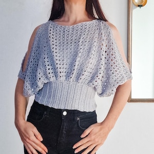 Op de afbeelding: Een witte keramische mok met een zwart handvat en de tekst "But First, Coffee" in een zwarte, vette letter. De mok staat op een wit oppervlak.