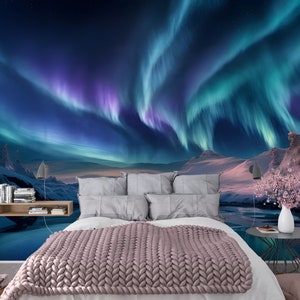 Può includere: Uno spettacolo vibrante di aurora boreale in tonalità di viola e verde illumina un paesaggio innevato. L'aurora si riflette in un lago ghiacciato in primo piano.