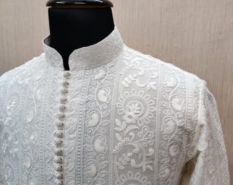 Op de afbeelding: Wit geborduurd overhemd met een opstaande kraag en knoopsluiting. Het overhemd heeft ingewikkelde bloemen- en paisleypatronen. Het overhemd met lange mouwen wordt op een mannequin getoond.