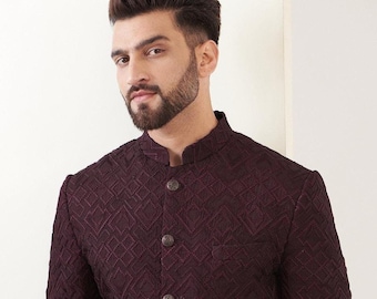 May include: A burgundy blazer with a geometric pattern and a mandarin collar. The blazer has three matching buttons and a tailored fit. The fabric appears to have a subtle texture, and the overall style is formal.