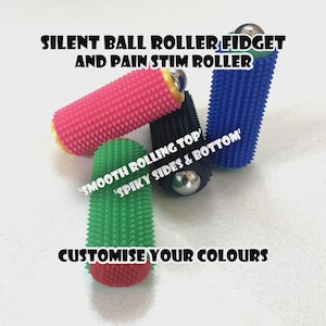 May include: A selection of spiky ball rollers in various colours, including pink, blue, green, and black. Each roller has a smooth rolling top and spiky sides and bottom, with a silver ball bearing. Text reads "SILENT BALL ROLLER FIDGET AND PAIN STIM ROLLER".