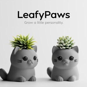 May include: Two grey cat-shaped planters with green and light green succulents. The planters have black eyes and whiskers. The text "LeafyPaws" and "Grow a little personality" are at the top.