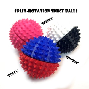 Op de afbeelding: Een verzameling stekelige ballen in roze, wit, zwart, blauw en rood. De ballen hebben een split-rotatieontwerp en zijn bedekt met kleine, puntige spikes. De tekst op de afbeelding luidt "SPLIT-ROTATION SPIKY BALL!" met de woorden "SPINNY", "ROLLY" en "OUCHIE".