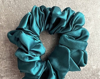 May include: Teal blue satin scrunchie for hair.