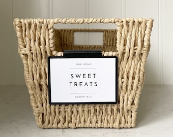 May include: A woven wicker basket with a black label that reads "Our Home Sweet Treats Essentials".