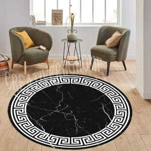 May include: Black and white round rug with a Greek key border. The rug has a marble pattern in the center.