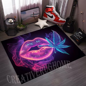 May include: A rectangular black rug featuring a neon-style design. The design includes a pair of lips with a lit cigarette and a cannabis leaf. The lips and leaf are outlined in pink and blue, with purple smoke effects. The text "CREATIVE PUGHOME" is at the bottom.