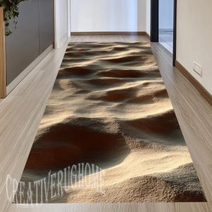 May include: A long rectangular runner rug featuring a high-contrast 3D print of rippled sand dunes in shades of beige, tan, and deep brown. The surface displays a textured appearance with light and shadow effects. The text CREATIVERUGHOME is visible.