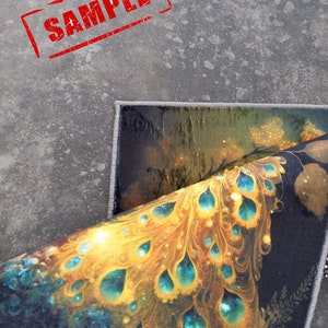 May include: A rolled-up rug with a vibrant peacock feather design in shades of gold, teal, and blue. The rug has a dark background and a white border. The word "SAMPLE" is stamped in red on the gray surface.