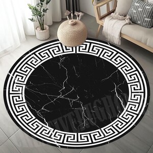 May include: Black and white round rug with a Greek key border and a marble pattern in the center.