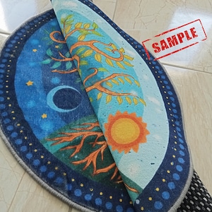 May include: A round, blue and yellow rug with a tree design and a sun and moon on either side. The rug has a gray border and a black non-slip backing.