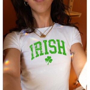 May include: White t-shirt with a green distressed graphic that says "IRISH" with a green shamrock underneath.