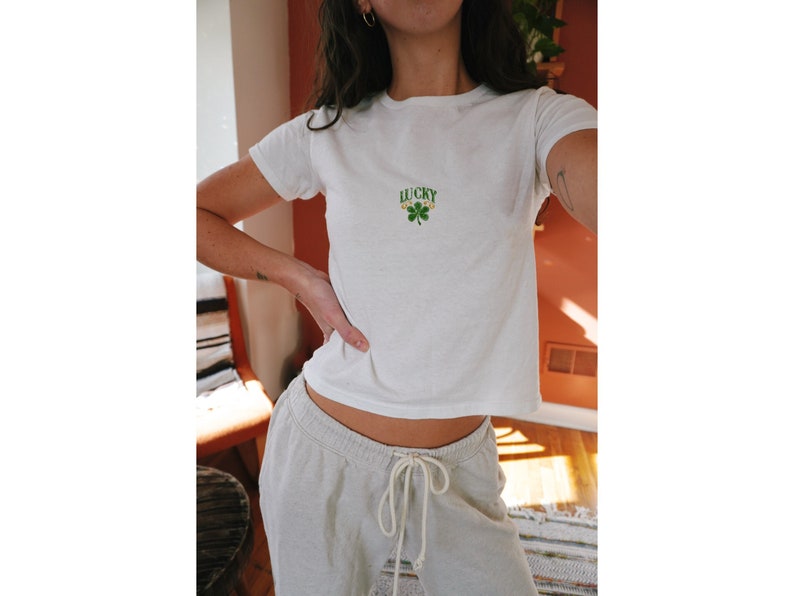 Cropped Tee Shirt inspired by 90s baby tee style for women, featuring the slogan 'Lucky You' with two shamrocks, ideal for St. Patrick's Day. Targets top Google SEO rankings for girls' shirts