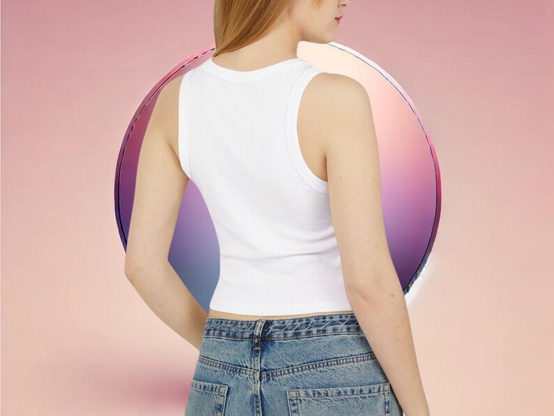 May include: A white sleeveless crop top with a ribbed texture. The top is worn by a person with long blonde hair and is paired with blue denim jeans.