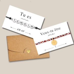 Peut inclure: Deux bracelets et une enveloppe marron avec un cœur doré. Un bracelet avec des perles blanches épelant "TEMOIN" sur un cordon noir. L'autre bracelet a un bracelet à motifs et un charme doré avec "Témoin".