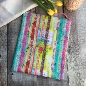 Puede incluir: Una cartera de mano de tela colorida con un dise&ntilde;o de patchwork de varias cintas, encaje y motivos florales en tonos de rosa, azul, verde, amarillo y rojo.