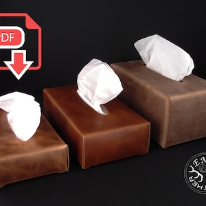 Puede incluir: Tres cubiertas de caja de pañuelos de cuero en diferentes tamaños. Las cubiertas son marrones y tienen un aspecto desgastado. La cubierta más grande está a la derecha, la más pequeña a la izquierda y la cubierta del medio está en el centro. Las cubiertas están hechas por Le Mole Leather.