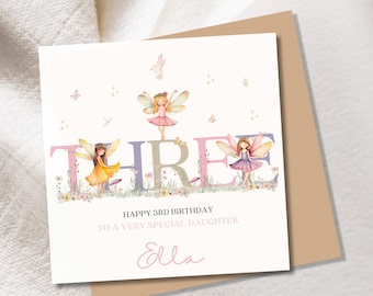 Puede incluir: Tarjeta de cumpleaños con la palabra "THREE" adornada con hadas. La tarjeta dice "HAPPY 3RD BIRTHDAY TO A VERY SPECIAL DAUGHTER" y está personalizada con "Ella". La tarjeta blanca tiene un sobre marrón, ideal para un tercer cumpleaños.