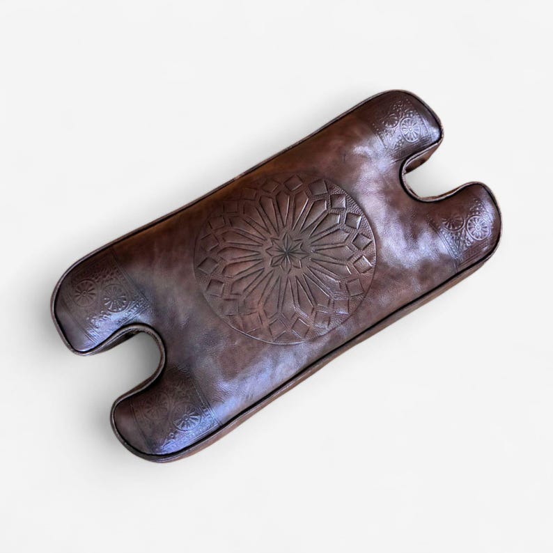 Dark brown handmade Moroccan leather camel stool cushion with traditional embossed pattern and custom cut-out shape for saddle stool horns.