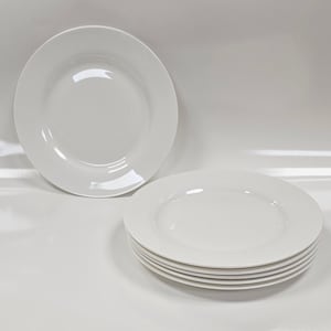 Pode incluir: Um conjunto de seis pratos de cerâmica branca. Os pratos são redondos com uma borda ligeiramente elevada. Um prato é posicionado separadamente, enquanto os outros estão empilhados. Os pratos têm um acabamento brilhante e são adequados para servir refeições.