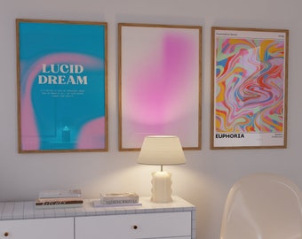 May include: Three framed wall art prints featuring abstract designs, including one with blue and pink gradients and the text "LUCID DREAM," one with a pink gradient, and one with a colorful marbled pattern and the text "EUPHORIA."