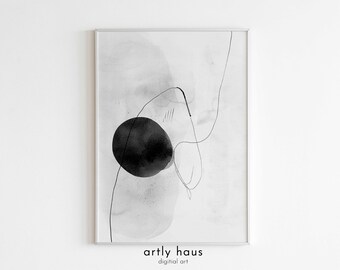 May include: A framed wall art print featuring a solid black circle on a white background with soft gray watercolor washes and thin, flowing black ink lines. The text 'artly haus digital art' is printed in black at the bottom of the frame.