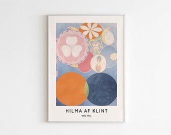 Puede incluir: Una impresión artística enmarcada que presenta una composición abstracta de círculos superpuestos en tonos naranja, rosa, azul y blanco. La obra incluye patrones florales y formas geométricas. El texto HILMA AF KLINT 1896-1944 aparece abajo.