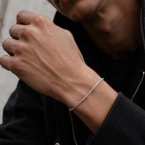 Puede incluir: Un brazalete de cadena de cuerda plateada. El brazalete está hecho de eslabones retorcidos y se usa en la muñeca. Una joya sencilla y elegante, un accesorio versátil. Ideal para complementar cualquier atuendo.