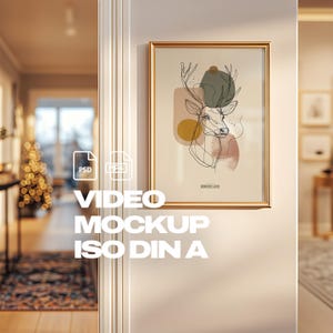 以下が含まれることがあります： 金、茶色、緑色の抽象的な形と鹿のイラストが描かれた額入りのアートプリント。アートワークは金のフレームに入っており、白い壁に掛けられています。「WONDERLAND」の文字が見えます。画像には「VIDEO MOCKUP ISO DIN A」の文字も含まれています。