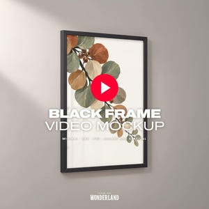 May include: A black frame containing a print of a branch with round leaves in shades of rust, sage green, and cream. The text BLACK FRAME VIDEO MOCKUP is overlaid in white, along with a red play button icon and the text FRAME ART WONDERLAND.