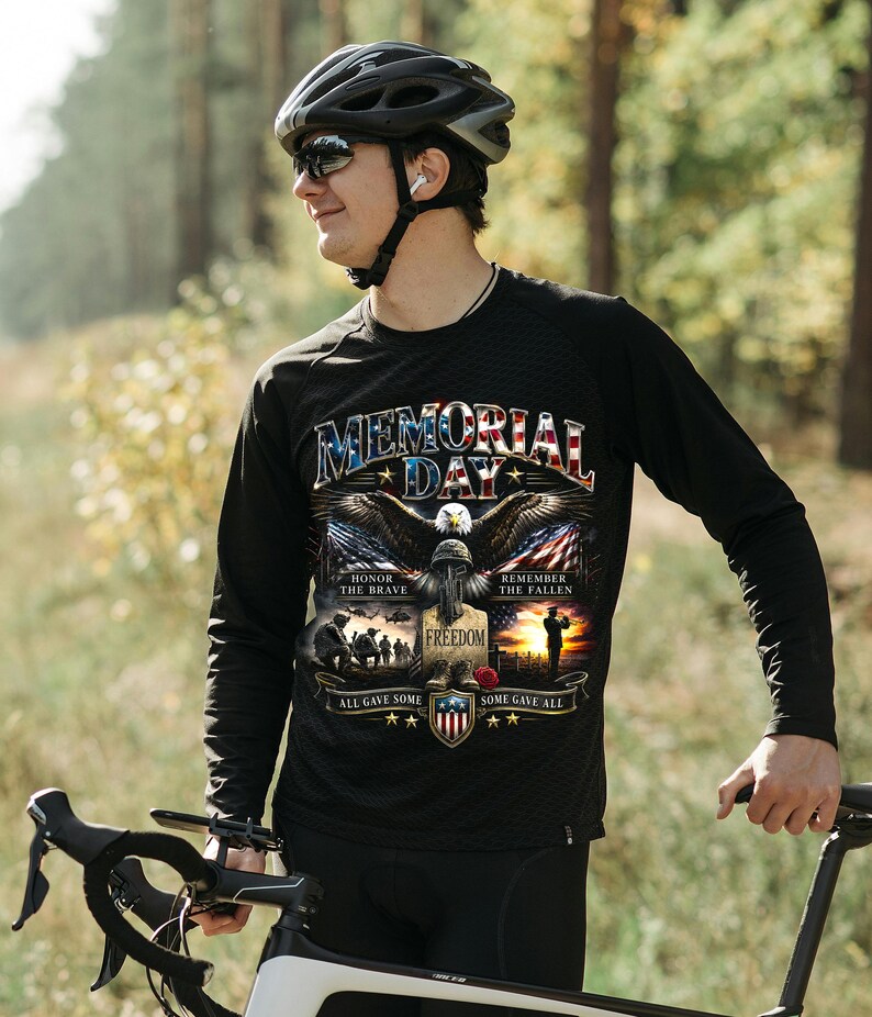 May include: Black long-sleeve shirt with a Memorial Day graphic featuring an eagle, American flag, and text. The shirt includes the phrases "Honor the Brave," "Remember the Fallen," and "All Gave Some, Some Gave All."