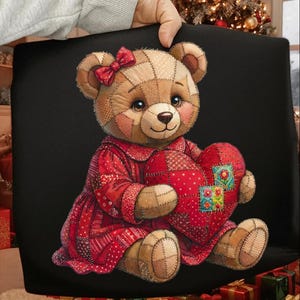 May include: A plush teddy bear with a patchwork design, wearing a red dress and holding a red heart. The bear has a red bow and is set against a black background. The heart has colorful floral patches.