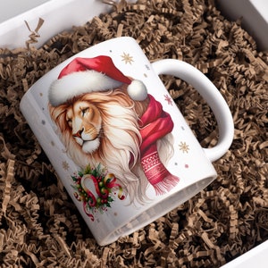 Puede incluir: Taza de cer&aacute;mica blanca con un dise&ntilde;o festivo que presenta un le&oacute;n con un gorro de Pap&aacute; Noel y una bufanda roja. El le&oacute;n tiene una corona de flores verde alrededor del cuello con una herradura dorada y cintas rojas. La taza tiene un asa blanca y un fondo blanco con copos de nieve y estrellas doradas.