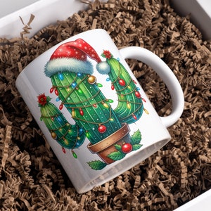 Op de afbeelding: Witte keramische mok met een kerstcactusontwerp. De cactus is versierd met een kerstmanmuts en kerstverlichting.