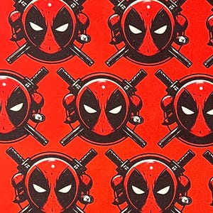 May include: Red fabric featuring a repeating pattern of Deadpool's mask and crossed katanas. The mask is red and black with white eyes, set against a bright red background. The katanas are black.