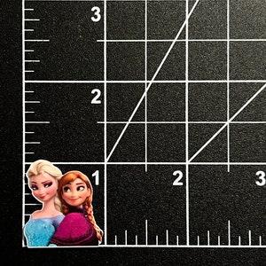 Puede incluir: Dos personajes de dibujos animados, uno con el pelo largo y rubio que lleva un vestido azul claro y el otro con el pelo largo y rojo que lleva un vestido morado, est&aacute;n de pie uno al lado del otro.