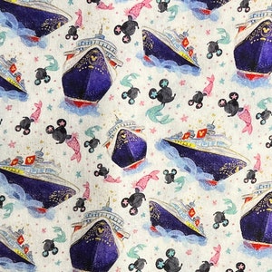 Puede incluir: Una tela blanca con un patrón repetido de un crucero azul y dorado, cabezas de Mickey Mouse y sirenas rosas y verdes. El fondo es blanco con pequeñas estrellas blancas.